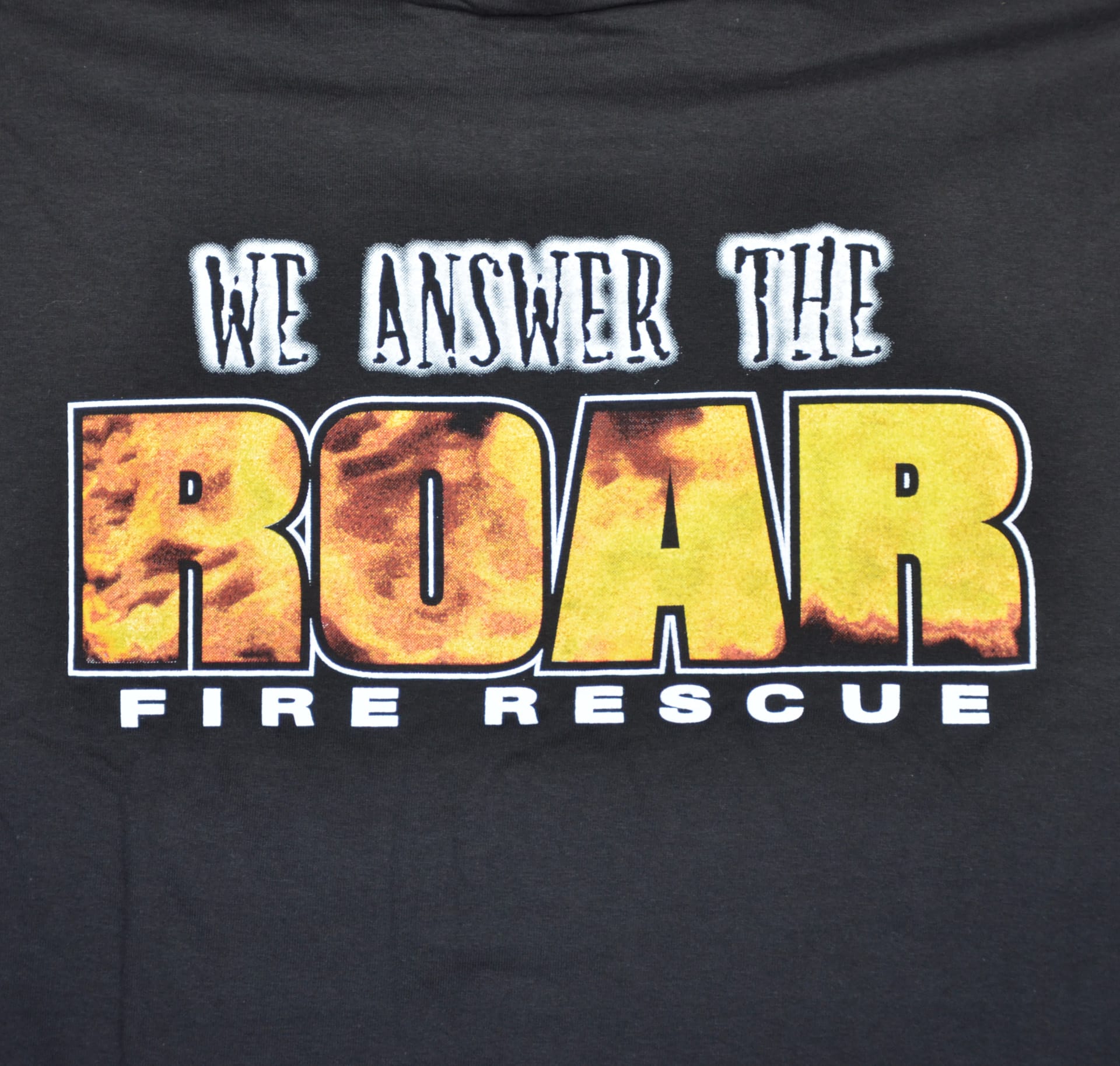 T-shirt featuring the phrase "We Answer the Roar" with a fire rescue theme, showcasing a bold and vibrant design.