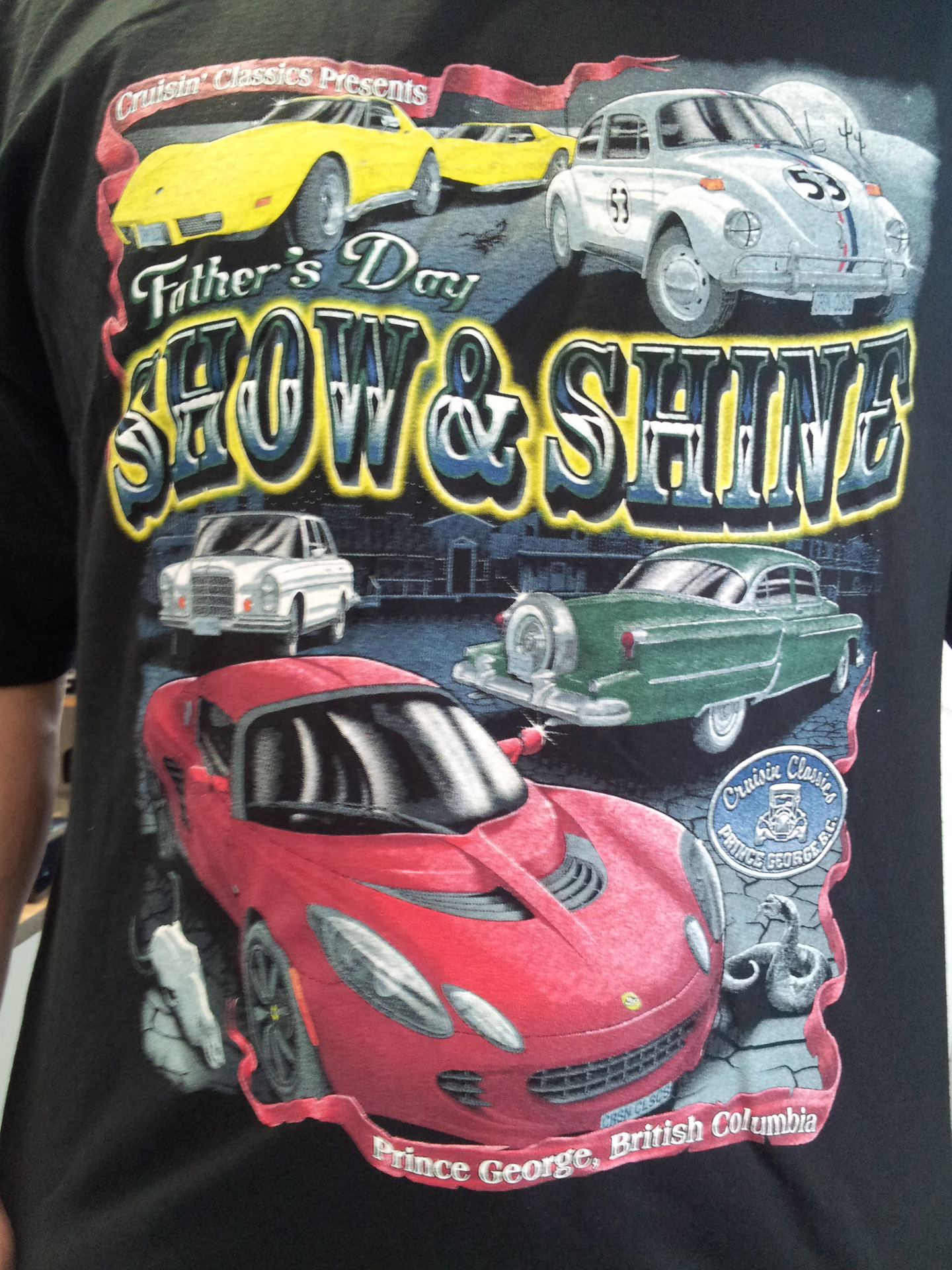A man wearing a shirt featuring a graphic of various cars.