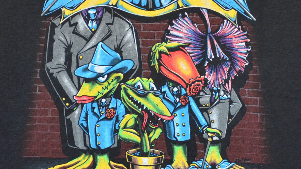 A t-shirt featuring a graphic of a man standing with two birds beside him.