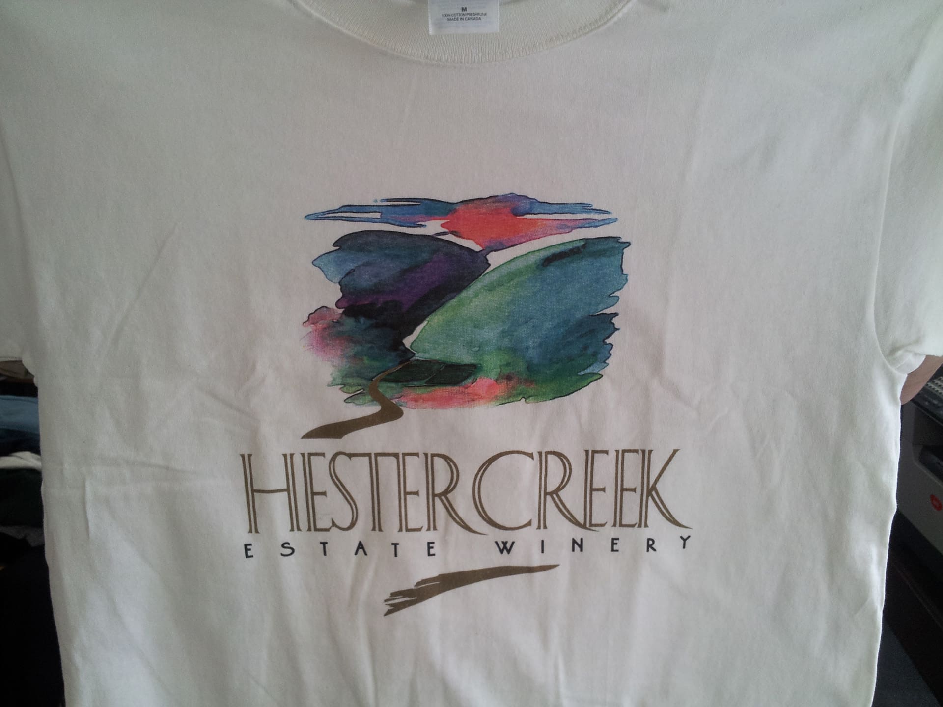 A white t-shirt featuring the text "Hester Creek Estate Winery" prominently displayed on the front.