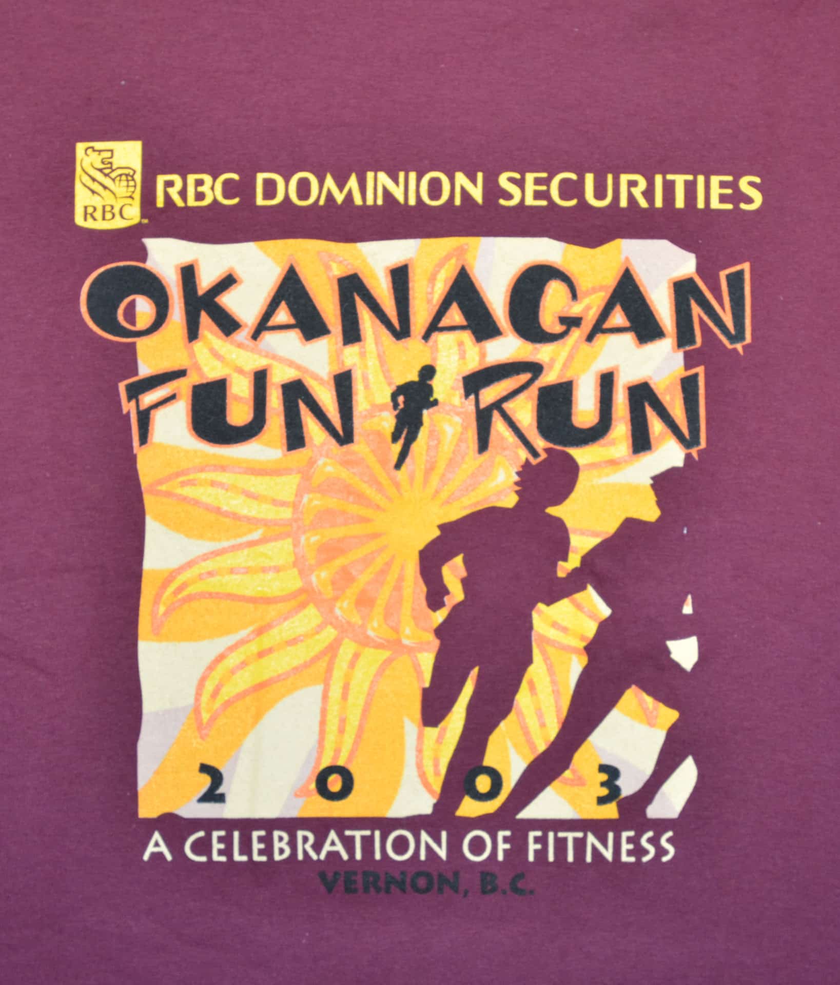 A t-shirt featuring the text "Okanagan Fun Run" in bold, colorful letters on a light background.