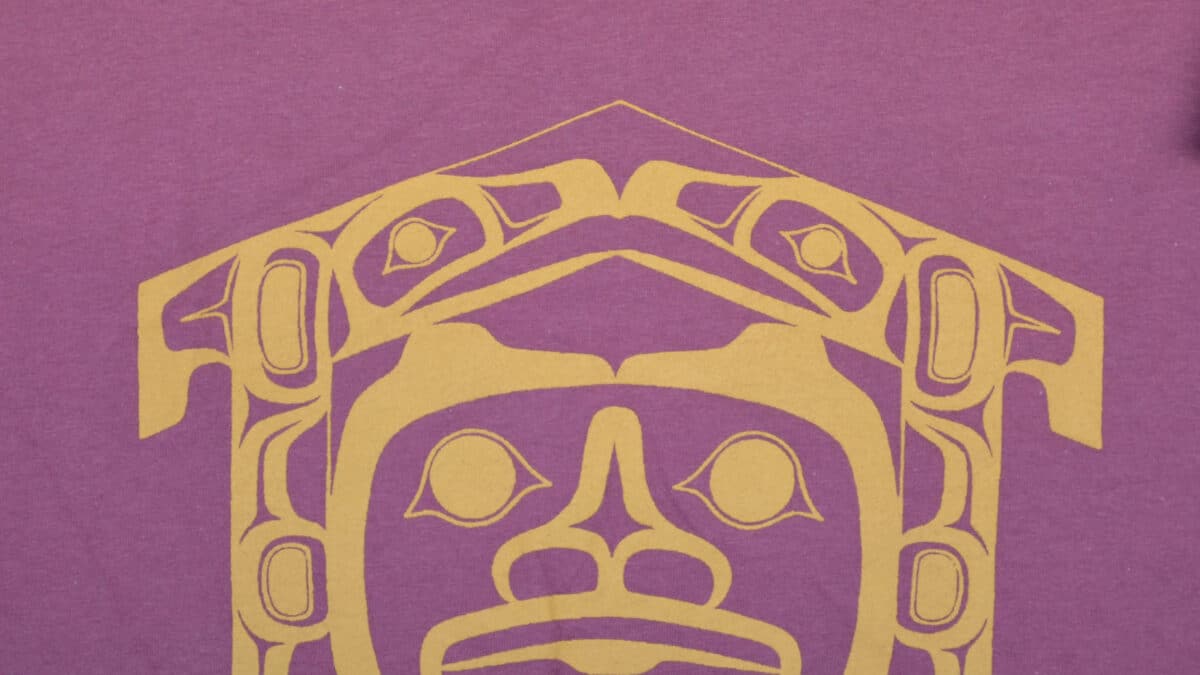 First Nations Longhouse shirt featuring traditional patterns and colors, symbolizing cultural heritage and community.
