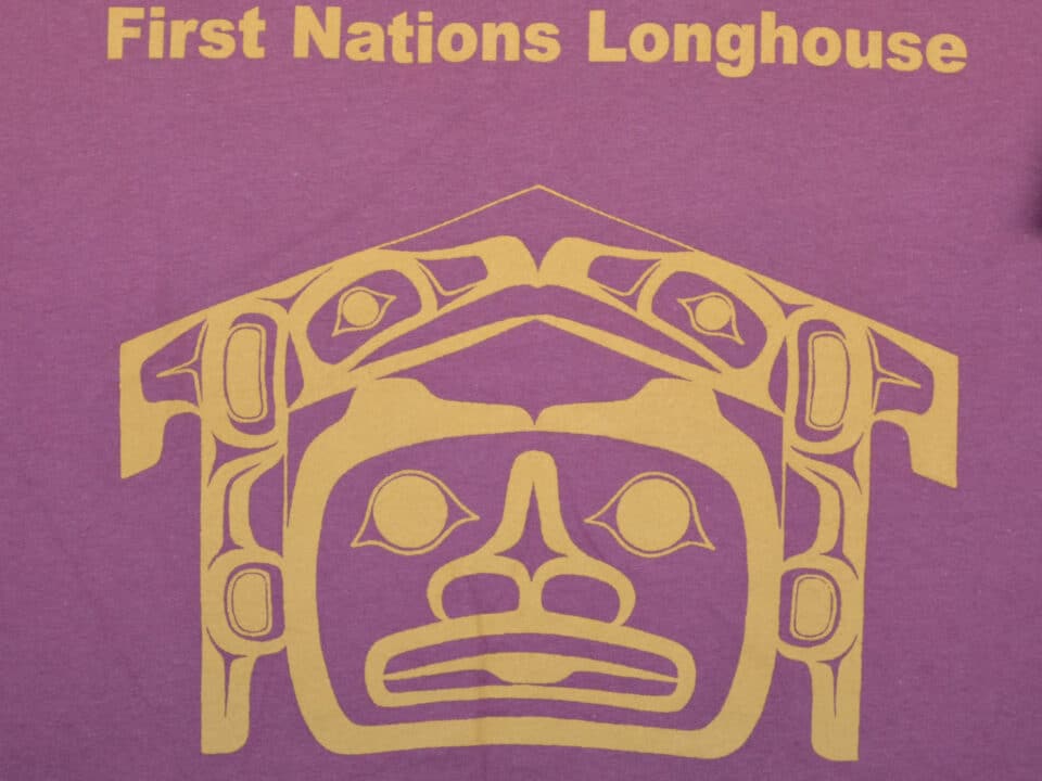 First Nations Longhouse shirt featuring traditional patterns and colors, symbolizing cultural heritage and community.