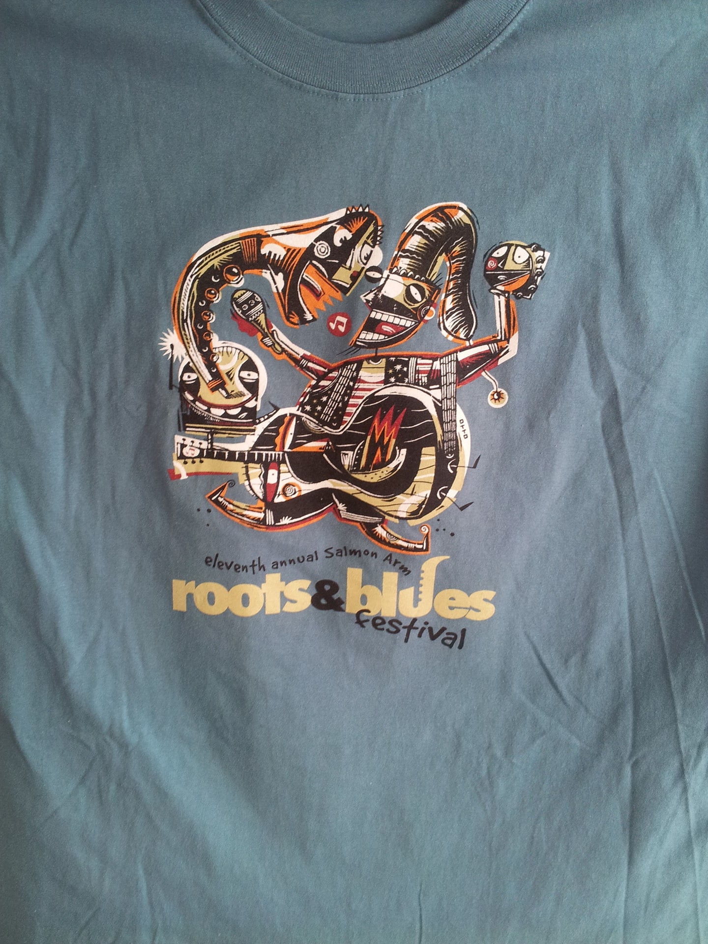 Roots and Blues Festival t-shirt featuring vibrant graphics celebrating music and culture.