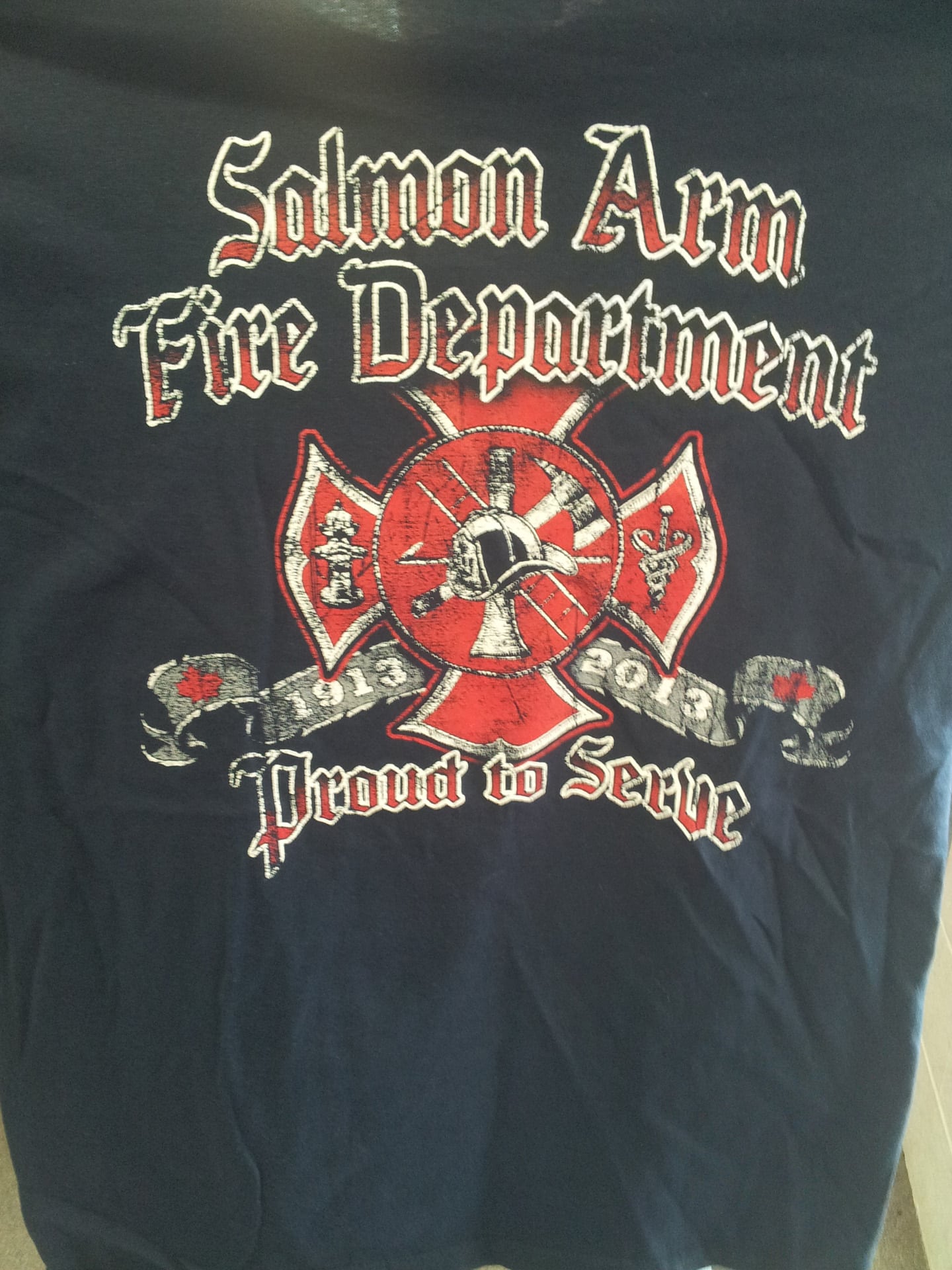 Salmon Arm Fire Department shirt featuring the department's logo and emblem on a black shirt.